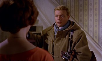 Movie still from “Peeping Tom” (1960), directed by Michael Powell – A man in a brown coat is holding a camera; Medium shot, Over the shoulder angle