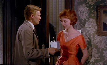 Movie still from “Peeping Tom” (1960), directed by Michael Powell – A man and a woman are holding a candle in their hands; Medium shot, Over the shoulder angle