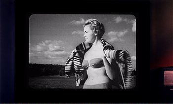 Movie still from “Peeping Tom” (1960), directed by Michael Powell – A black and white photo of a woman in a bikini; Medium shot, Low angle