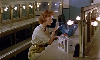 Movie still from “Peeping Tom” (1960), directed by Michael Powell – A woman sitting in front of an electrical device; Medium shot, Low angle