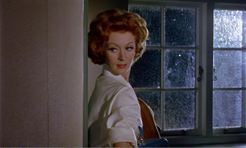 Movie still from “Peeping Tom” (1960), directed by Michael Powell – An older woman standing in front of a window; Close Up shot, Low angle