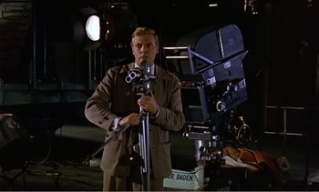 Movie still from “Peeping Tom” (1960), directed by Michael Powell – A man standing in front of a movie camera; Medium shot, Low angle