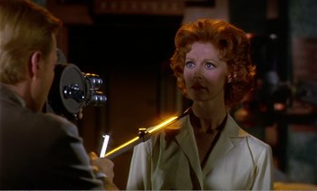 Movie still from “Peeping Tom” (1960), directed by Michael Powell – A woman is holding an object up to her face; Close Up shot, Low angle