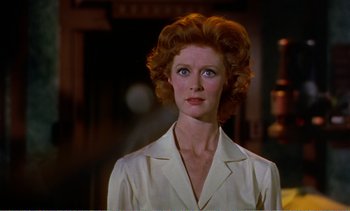 Movie still from “Peeping Tom” (1960), directed by Michael Powell – An older woman with red hair wearing a white shirt; Close Up shot, Low angle