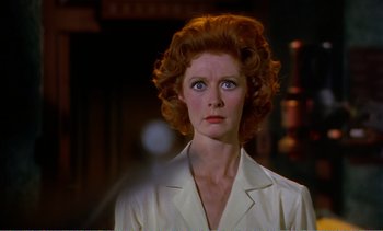 Movie still from “Peeping Tom” (1960), directed by Michael Powell – A person wearing a suit and tie; Close Up shot, Over the shoulder angle