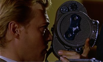 Movie still from “Peeping Tom” (1960), directed by Michael Powell – A person holding an old movie camera; Extreme Close Up shot, Overhead angle
