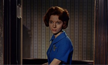 Movie still from “Peeping Tom” (1960), directed by Michael Powell – A woman in a blue shirt is posing for a picture; Medium shot, Low angle