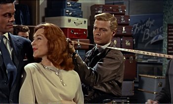 Movie still from “Peeping Tom” (1960), directed by Michael Powell – A man and a woman are standing in front of suitcases; Medium shot, Over the shoulder angle
