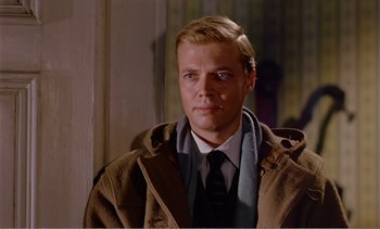 Movie still from “Peeping Tom” (1960), directed by Michael Powell – A man wearing a brown coat and a tie; Close Up shot, Over the shoulder angle