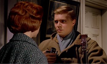 Movie still from “Peeping Tom” (1960), directed by Michael Powell – A young man holding a camera talking to a young woman; Close Up shot, Over the shoulder angle