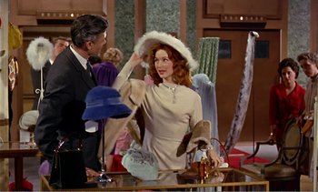 Movie still from “Peeping Tom” (1960), directed by Michael Powell – A man and a woman are looking at hats on a table; Medium shot, Over the shoulder angle