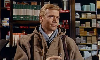 Movie still from “Peeping Tom” (1960), directed by Michael Powell – A man in a brown jacket holding a gun; Close Up shot, Low angle
