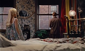 Movie still from “Peeping Tom” (1960), directed by Michael Powell – A man looking out of a window in a bedroom; Wide shot, Over the shoulder angle