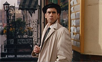 Movie still from “Peeping Tom” (1960), directed by Michael Powell – A man wearing a hat and a trench coat standing outside; Medium shot, Low angle