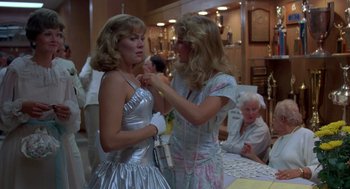 Movie still from “Peggy Sue Got Married” (1986), directed by Francis Ford Coppola – Two women dressed up in a silver dress; Medium shot, Over the shoulder angle