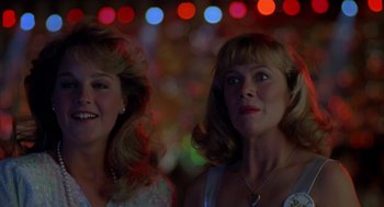 Movie still from “Peggy Sue Got Married” (1986), directed by Francis Ford Coppola – A couple of women standing next to each other in a room; Close Up shot, Low angle