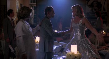 Movie still from “Peggy Sue Got Married” (1986), directed by Francis Ford Coppola – A man and a woman shaking hands at a party; Medium shot, Over the shoulder angle