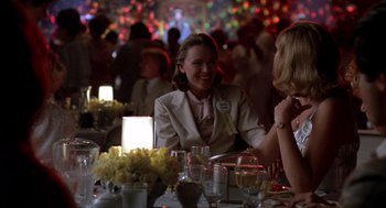 Movie still from “Peggy Sue Got Married” (1986), directed by Francis Ford Coppola – Two women are sitting at a table in front of candles; Medium shot, Over the shoulder angle