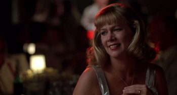 Movie still from “Peggy Sue Got Married” (1986), directed by Francis Ford Coppola – A woman with blonde hair and a silver top; Close Up shot, Low angle