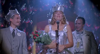 Movie still from “Peggy Sue Got Married” (1986), directed by Francis Ford Coppola – A woman wearing a crown and holding a bouquet of roses; Medium shot, Low angle