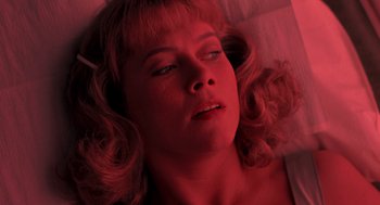 Movie still from “Peggy Sue Got Married” (1986), directed by Francis Ford Coppola – A woman laying on the ground with her eyes closed; Close Up shot, Overhead angle