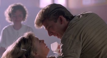 Movie still from “Peggy Sue Got Married” (1986), directed by Francis Ford Coppola – A man and a woman are smiling at each other; Close Up shot, Over the shoulder angle