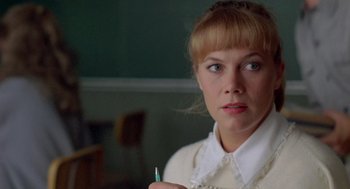 Movie still from “Peggy Sue Got Married” (1986), directed by Francis Ford Coppola – A woman holding a pen in her hand; Close Up shot, Over the shoulder angle