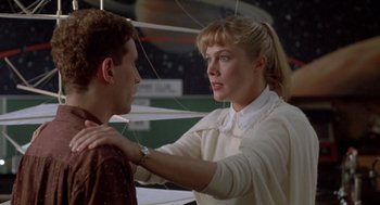 Movie still from “Peggy Sue Got Married” (1986), directed by Francis Ford Coppola – A woman is touching a man's face in front of a space background; Medium shot, Over the shoulder angle