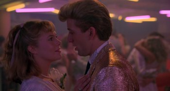 Movie still from “Peggy Sue Got Married” (1986), directed by Francis Ford Coppola – A man and a woman are kissing in a dance floor; Close Up shot, Over the shoulder angle