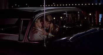 Movie still from “Peggy Sue Got Married” (1986), directed by Francis Ford Coppola – A woman and a child in a car at night; Medium shot, Over the shoulder angle