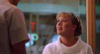 Movie still from “Peggy Sue Got Married” (1986), directed by Francis Ford Coppola – A woman in a white sweater looking up at the sky; Close Up shot, Over the shoulder angle