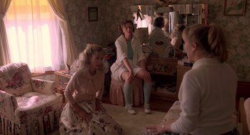 Movie still from “Peggy Sue Got Married” (1986), directed by Francis Ford Coppola – A group of women sitting in a living room together; Medium shot, High angle