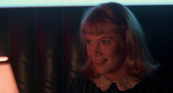 Movie still from “Peggy Sue Got Married” (1986), directed by Francis Ford Coppola – A person wearing a dress smiling; Close Up shot, Over the shoulder angle