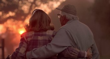 Movie still from “Peggy Sue Got Married” (1986), directed by Francis Ford Coppola – An older man and a younger woman are hugging; Medium shot, Over the shoulder angle