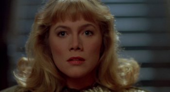 Movie still from “Peggy Sue Got Married” (1986), directed by Francis Ford Coppola – A woman with blonde hair and blue eyes; Close Up shot, Low angle