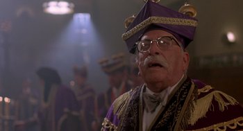 Movie still from “Peggy Sue Got Married” (1986), directed by Francis Ford Coppola – An old man wearing a purple hat and glasses; Close Up shot, Low angle