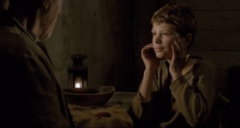 Movie still from “Pelle the Conqueror” (1987), directed by Bille August – A young man sitting at a table talking on the phone; Close Up shot, Over the shoulder angle