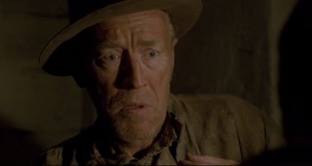 Movie still from “Pelle the Conqueror” (1987), directed by Bille August – An older man wearing a hat and looking at the camera; Close Up shot, Low angle