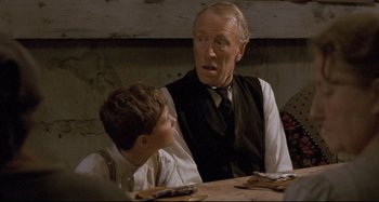 Movie still from “Pelle the Conqueror” (1987), directed by Bille August – An older man and a young boy sitting at a table; Close Up shot, Over the shoulder angle