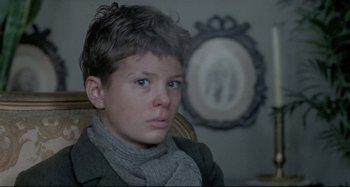 Movie still from “Pelle the Conqueror” (1987), directed by Bille August – A young boy sitting in front of an ornate mirror; Close Up shot, Over the shoulder angle