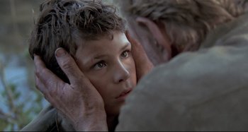 Movie still from “Pelle the Conqueror” (1987), directed by Bille August – A man touching a boy's face with his hands; Close Up shot, Over the shoulder angle