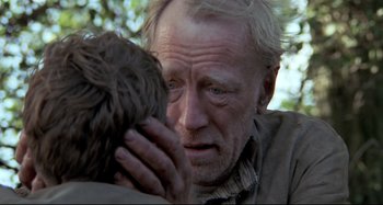 Movie still from “Pelle the Conqueror” (1987), directed by Bille August – An older man holding a young boy in his arms; Close Up shot, Over the shoulder angle