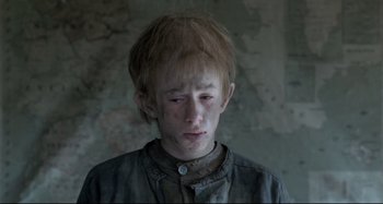 Movie still from “Pelle the Conqueror” (1987), directed by Bille August – A young man with a sad look on his face; Close Up shot, Low angle