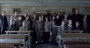 Movie still from “Pelle the Conqueror” (1987), directed by Bille August – A group of people standing in front of a fire place; Wide shot, High angle