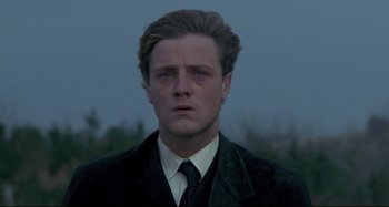 Movie still from “Pelle the Conqueror” (1987), directed by Bille August – A person wearing a suit and tie; Close Up shot, Low angle