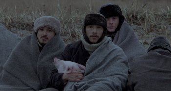 Movie still from “Pelle the Conqueror” (1987), directed by Bille August – A group of men wrapped in blankets and holding a pig; Close Up shot, Low angle