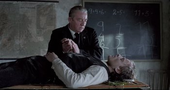 Movie still from “Pelle the Conqueror” (1987), directed by Bille August – A man in a black suit and a man in a white shirt; Medium shot, Over the shoulder angle