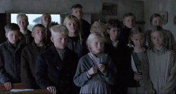 Movie still from “Pelle the Conqueror” (1987), directed by Bille August – A group of young people standing together in a room; Medium shot, High angle