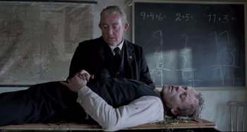 Movie still from “Pelle the Conqueror” (1987), directed by Bille August – A man in a black suit and a man in a white shirt; Medium shot, Over the shoulder angle