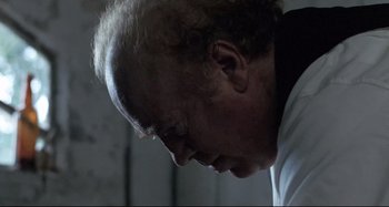 Movie still from “Pelle the Conqueror” (1987), directed by Bille August – An older man is looking down at his head; Close Up shot, Low angle